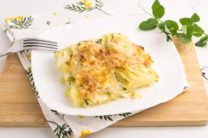 Potatoes with zucchini in creamy sauce in the oven