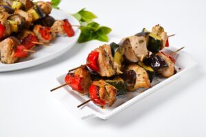 Barbecue on skewers with vegetables in the oven