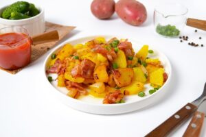 Potatoes with bacon in a pan at home